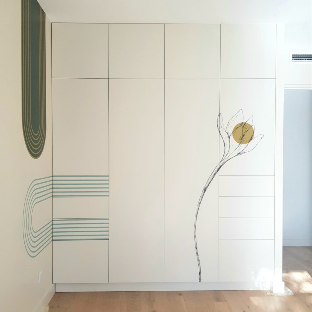 Armoire Encastrée Design avec Fresque Artistique Fleurie Armoire blanche encastrée avec décorations artistiques de fleurs et d'arches géométriques vertes dans une chambre moderne.