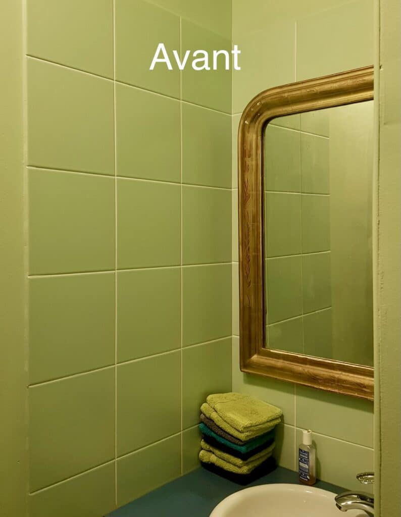 Mur de carrelage vert, miroir doré et serviettes avec texte Avant pour une rénovation de salle de bain.