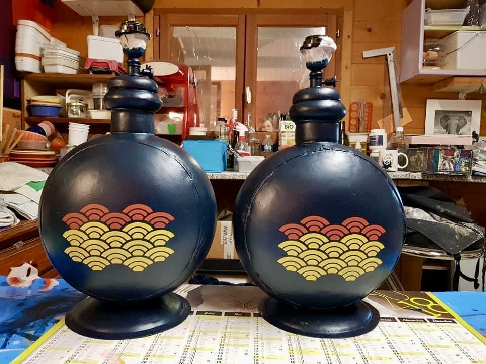 Lampes de Table avec Motifs de Vagues Japonaises Seigaiha Paire de lampes rondes bleu marine avec motifs de vagues japonaises rouges et jaunes dans un atelier de création.