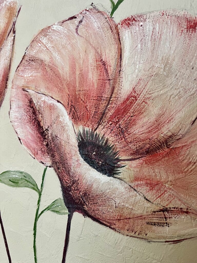 Gros plan d'un pavot rose et rouge texturé à la peinture acrylique avec un cœur noir sur fond crème.