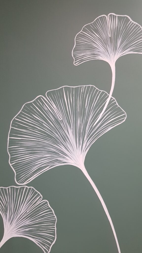 Feuilles de ginkgo en traits blancs sur fond vert sauge minimaliste.